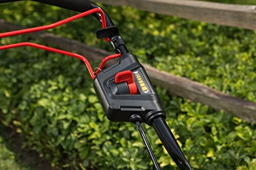 Closeup of a lawn mower handle with red and black controls.