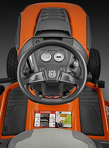 Top view of a lawn tractor dashboard with steering wheel and controls.