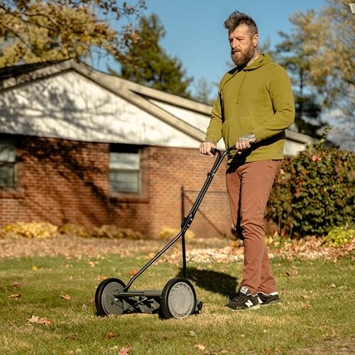 Man using a manual lawn mower on a sunny day