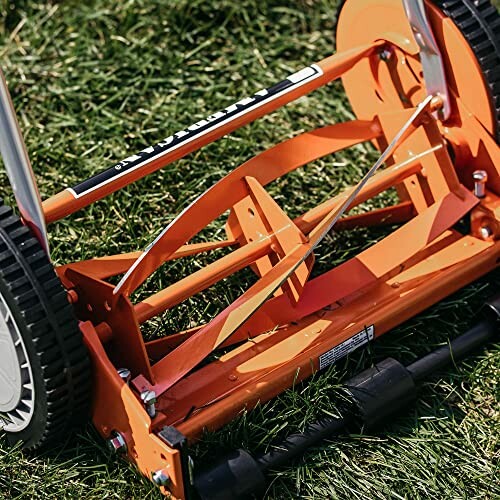 Close-up of a manual lawn mower on grass