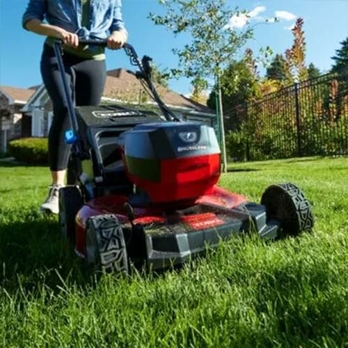 Person using a lawn mower on a grassy lawn.