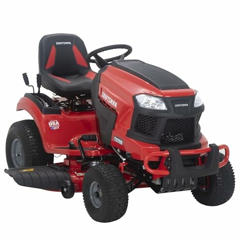 Red riding lawn mower with black seat and steering wheel.